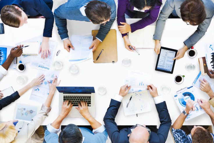 Draufsicht eines Schreibtischs bei einem Meeting