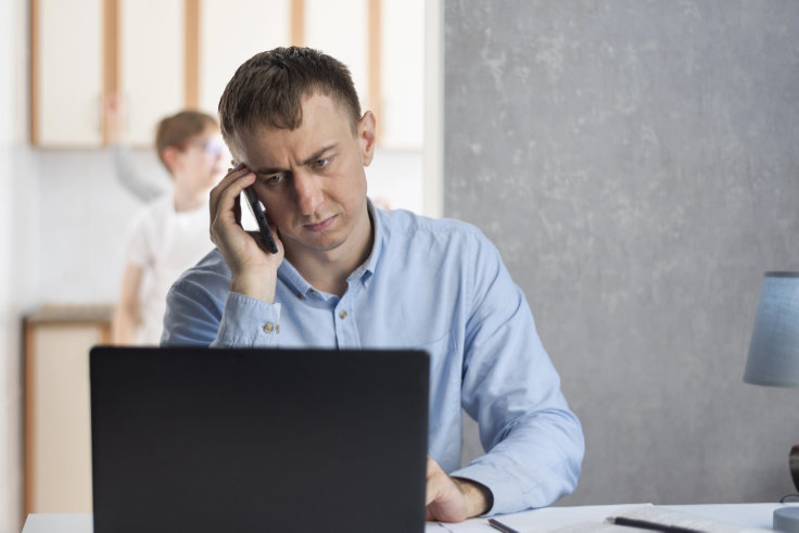 Mann im privaten Umfeld genervt am Smartphone