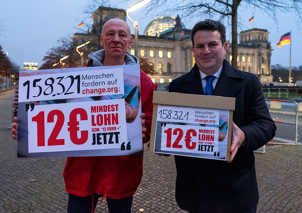 Ein DHL-Fahrer übergibt Minister Heil Unterschriften zum Mindestlohn