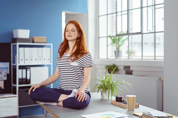 Frau beim Yoga im Büro