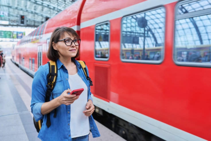 Frau am Bahnsteig neben einem Zug